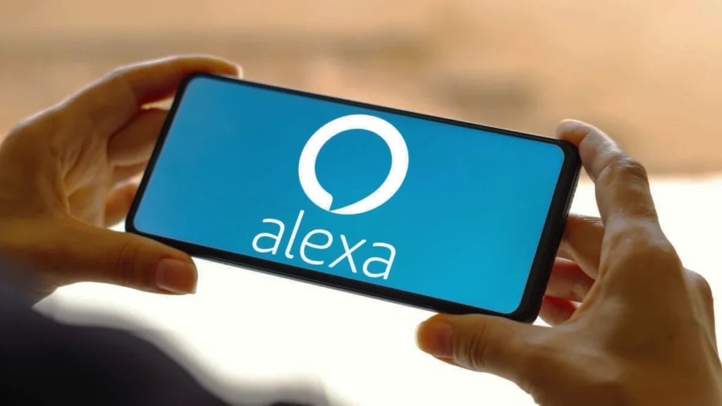 Smartphone exibindo o app Alexa nas mãos de uma pessoa.