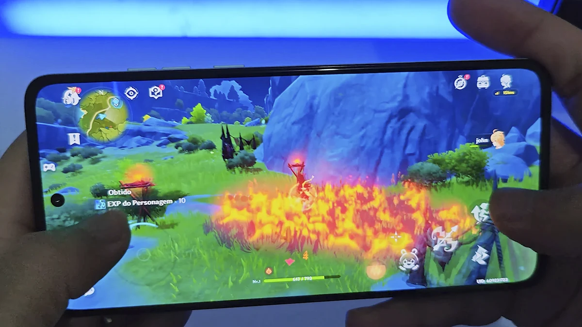 Smartphone Moto G84 exibindo o jogo Genshin Impact em execução, com gráficos detalhados e performance fluida.