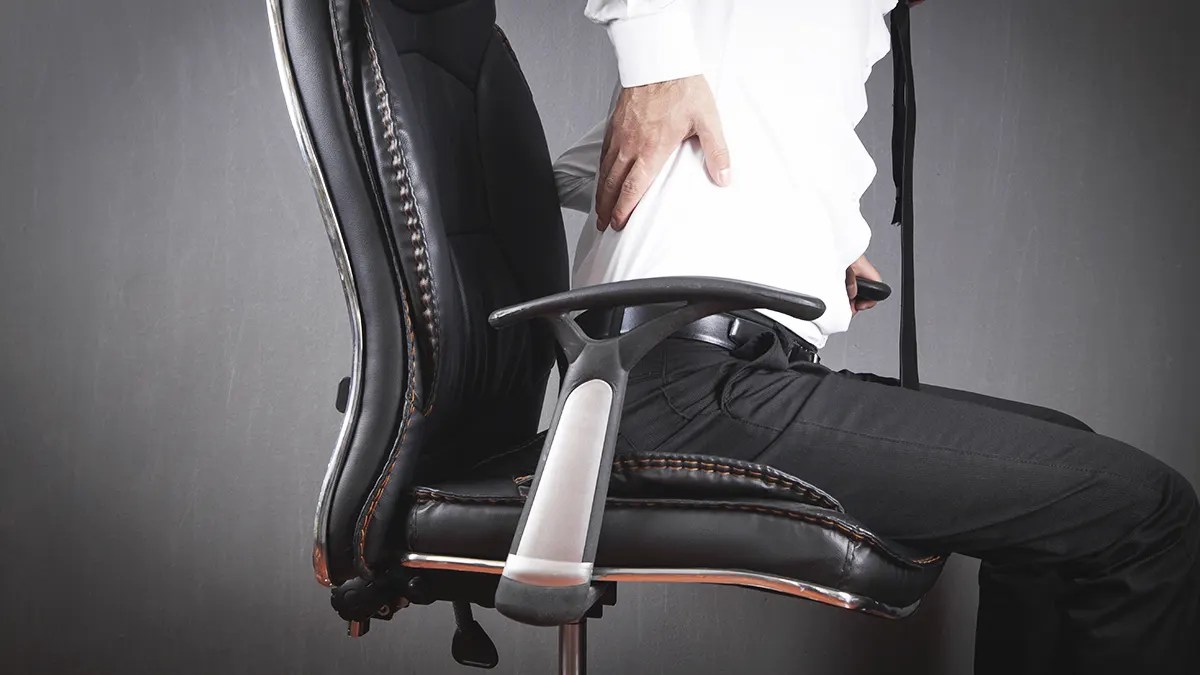Homem sentado em uma cadeira de escritório ergonômica moderna com encosto em mesh e braços ajustáveis